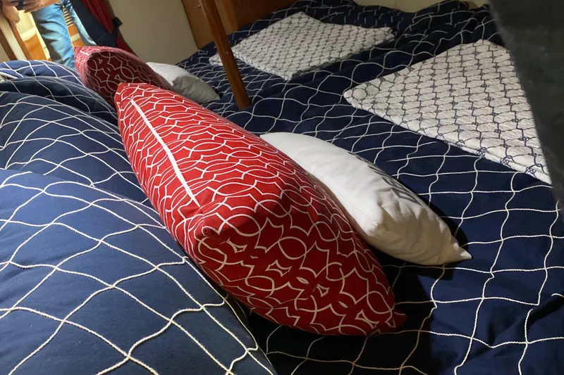 Dealer-ship Yacht Photos Pics Interior of 2004 Fountain 48 Express Cruiser with patterned bedding and pillows.