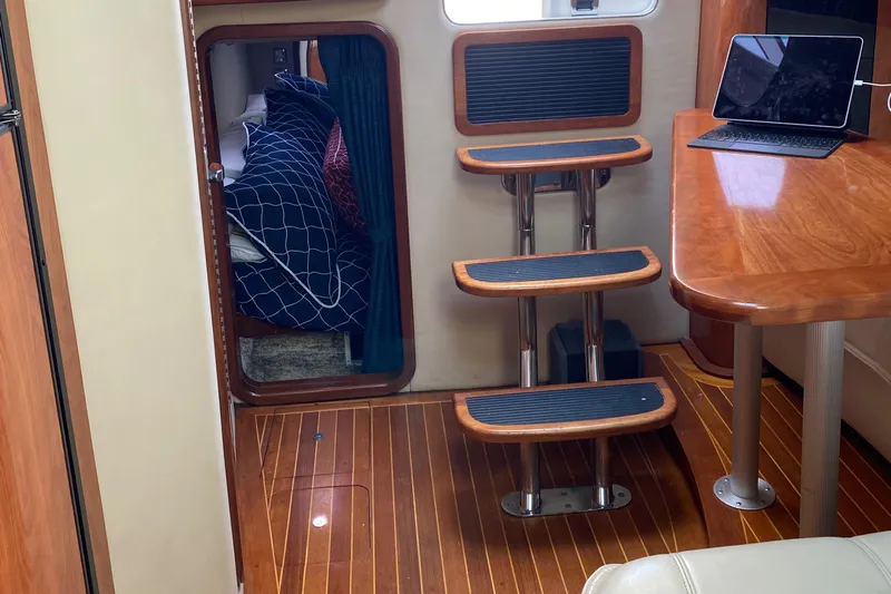Dealer-ship Yacht Photos Pics Interior of 2004 Fountain 48 Express Cruiser with wooden flooring and compact cabin space.