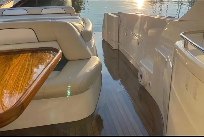 Dealer-ship Yacht Photos Pics Luxurious 2004 Fountain 48 Express Cruiser interior with elegant seating and wooden table.