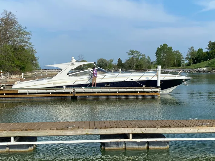 Dealer-ship Yacht Photos Pics 2004 Fountain 48 Express Cruiser docked on a calm lake with clear skies.