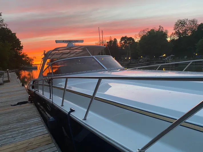 Dealer-ship Yacht Photos Pics 2004 Fountain 48 Express Cruiser docked at sunset with vibrant sky.