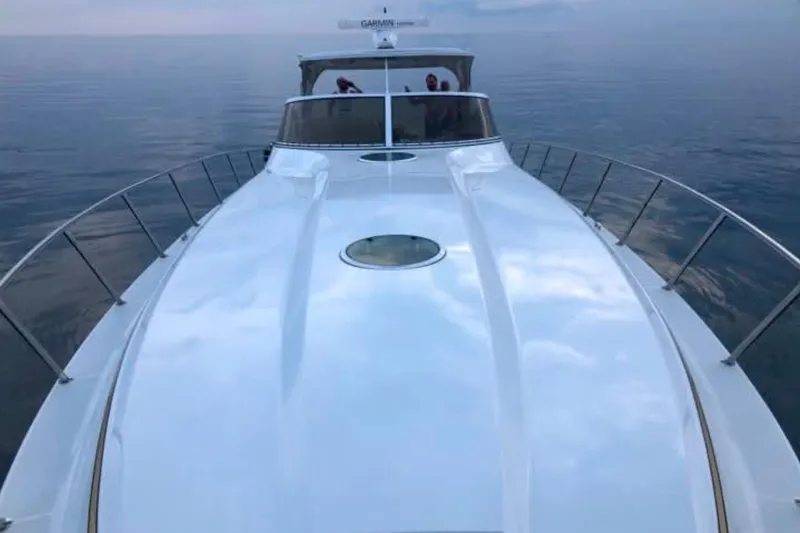 Dealer-ship Yacht Photos Pics 2004 Fountain 48 Express Cruiser on calm water, showcasing sleek design and spacious deck.