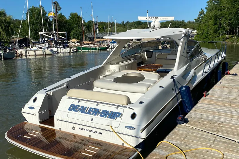 Dealer-ship Yacht Photos Pics 2004 Fountain 48 Express Cruiser docked at a marina, featuring sleek design and spacious seating.