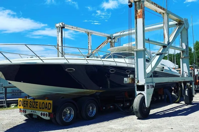 Dealer-ship Yacht Photos Pics 2004 Fountain 48 Express Cruiser on trailer, labeled "Oversize Load," under blue sky.