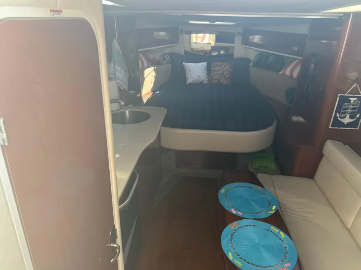 Baileys Dinghy Yacht Photos Pics Interior of 2010 Sea Ray 350 Sundancer with bed, kitchenette, and seating area.