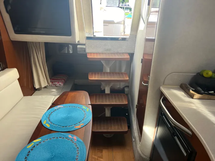 Baileys Dinghy Yacht Photos Pics Interior of 2010 Sea Ray 350 Sundancer yacht with wooden steps and dining area.