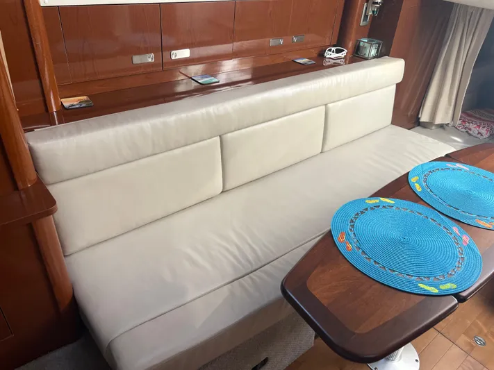 Baileys Dinghy Yacht Photos Pics Interior of 2010 Sea Ray 350 Sundancer with cream sofa and wooden table.
