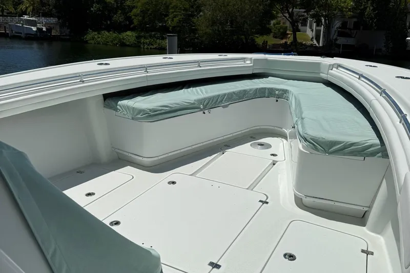  Yacht Photos Pics 2021 Yellowfin 39 boat deck with cushioned seating, docked near lush greenery.