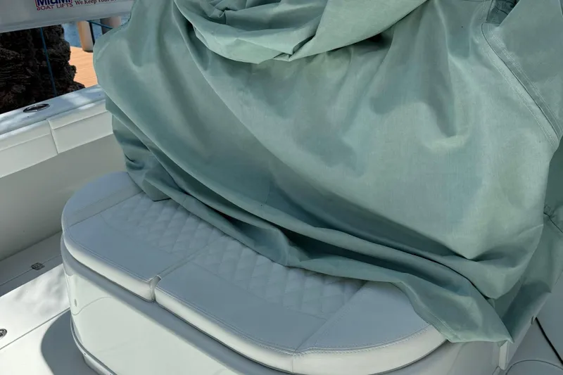  Yacht Photos Pics 2021 Yellowfin 39 boat seat with protective cover, showcasing quilted white upholstery.
