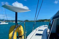 Nautitech 40 Open 2022 catamaran sailing on clear blue waters under a sunny sky.