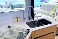 Modern kitchen on 2022 Nautitech 40 Open catamaran with ocean view and dual sinks.