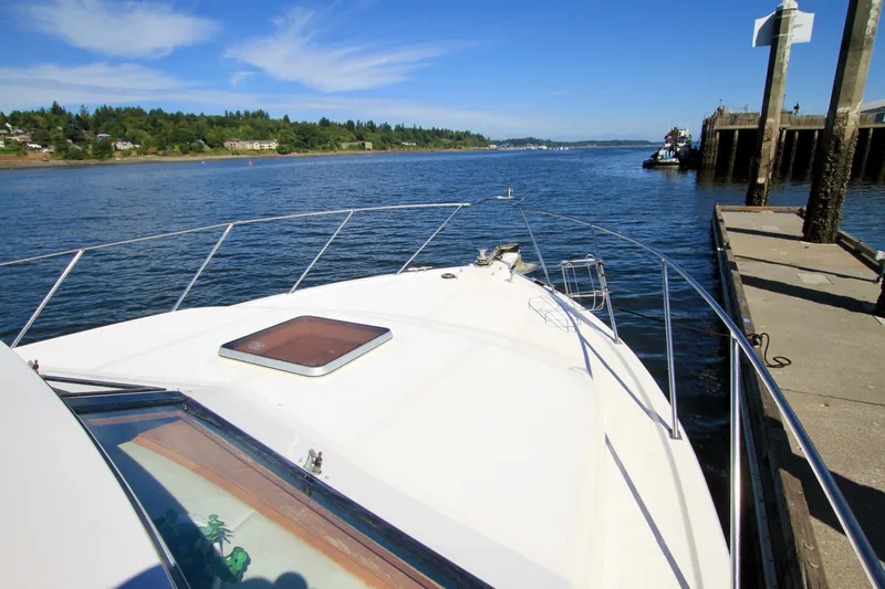 Sea Mistress Yacht Photos Pics 1987 Ocean Alexander 42 yacht docked by a scenic waterfront under clear blue skies.