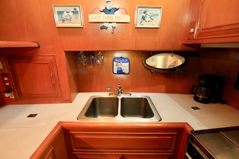 Sea Mistress Yacht Photos Pics 1987 Ocean Alexander 42 yacht kitchen with double sink, wooden cabinets, and nautical decor.