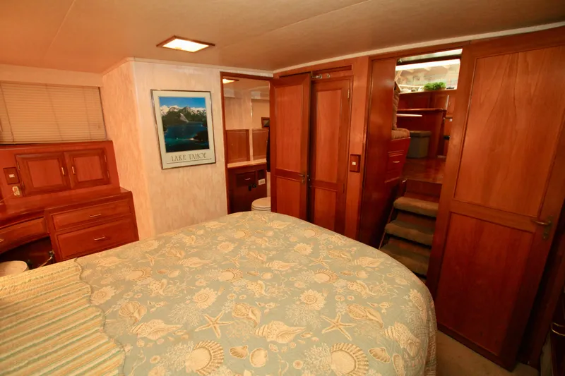 Sea Mistress Yacht Photos Pics Cozy bedroom in 1987 Ocean Alexander 42 yacht with wood paneling and nautical decor.