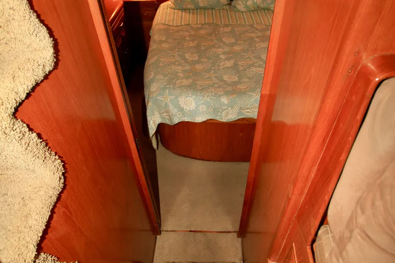 Sea Mistress Yacht Photos Pics Cozy cabin interior of 1987 Ocean Alexander 42 yacht with wooden finish and patterned bedding.