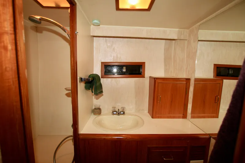 Sea Mistress Yacht Photos Pics 1987 Ocean Alexander 42 yacht bathroom with shower, sink, and wooden cabinets.