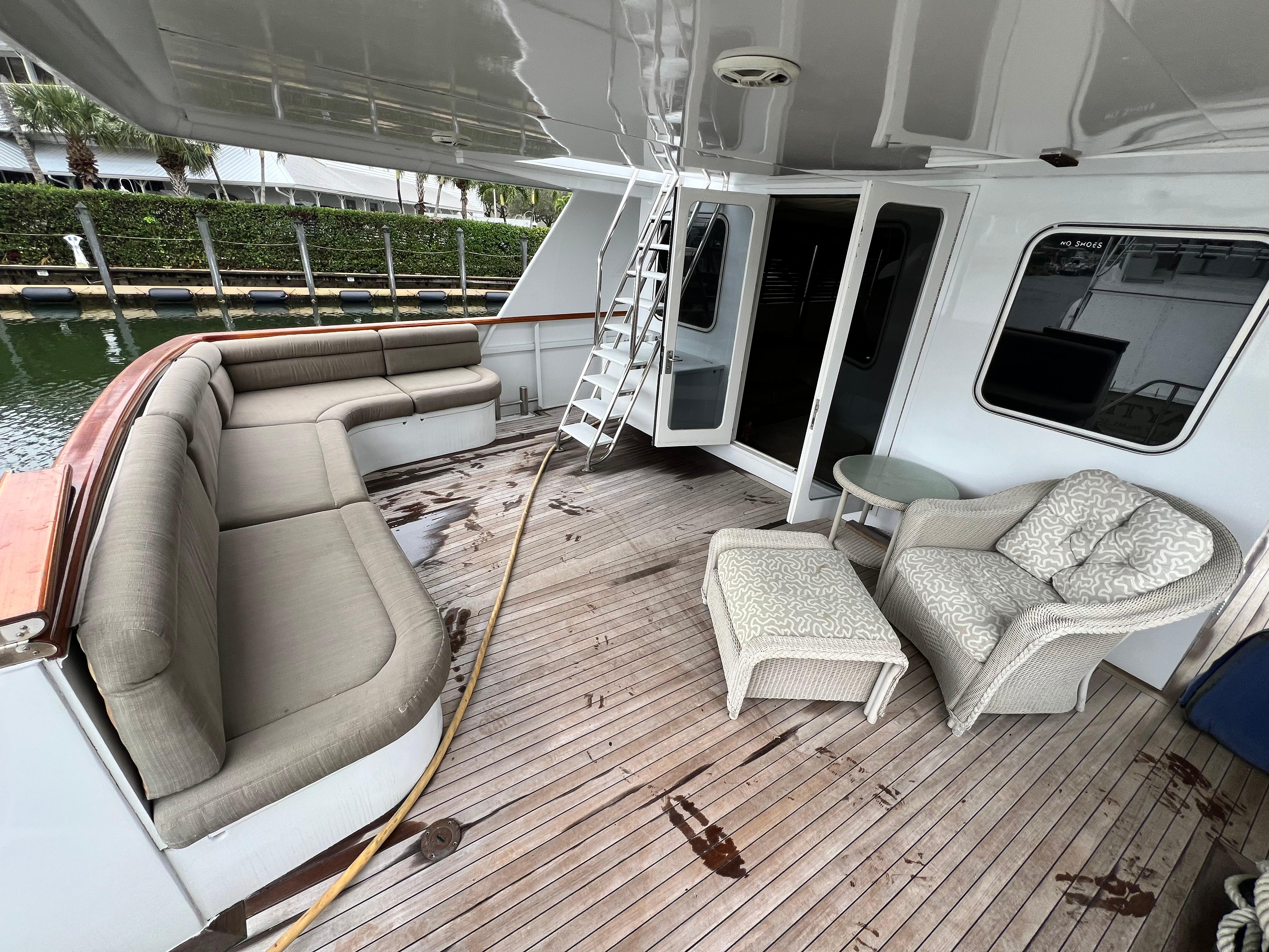 Spacious deck of 1988 Custom Steel Motor Yacht with seating and table.