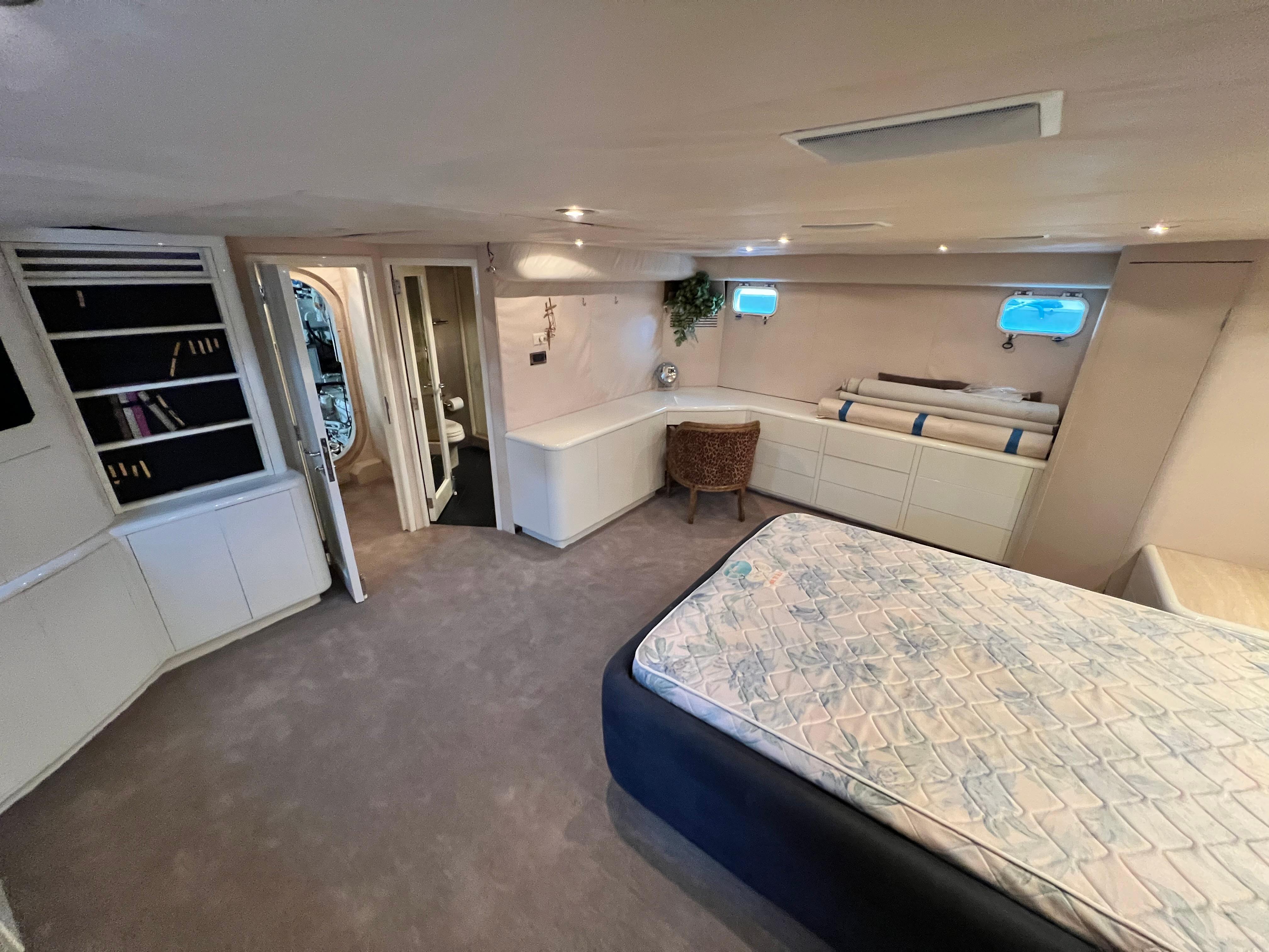 Luxurious interior of 1988 Custom Steel Motor Yacht with bed, seating, and storage.