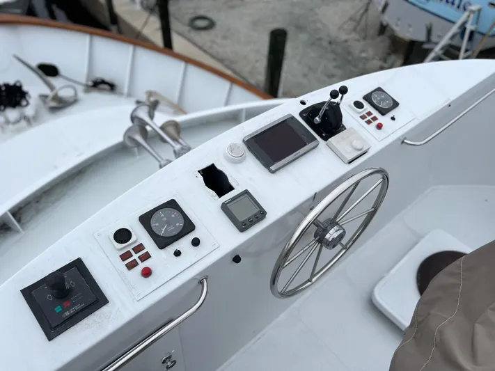Ain't No Big Thing Yacht Photos Pics Control panel of a 1988 Custom Steel Motor Yacht with steering wheel and navigation instruments.