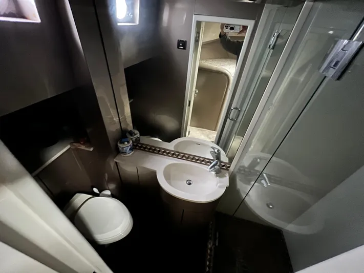 Ain't No Big Thing Yacht Photos Pics Compact yacht bathroom with sink, toilet, and shower in a 1988 Custom Steel Motor Yacht.