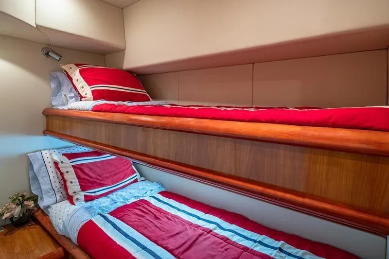 Yacht Photos Pics Bunk beds with red and blue bedding in a 2000 Sunseeker Manhattan 74 yacht cabin.