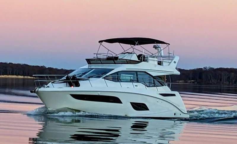  Yacht Photos Pics 2017 Sea Ray Fly 460 yacht cruising on calm water at sunset.
