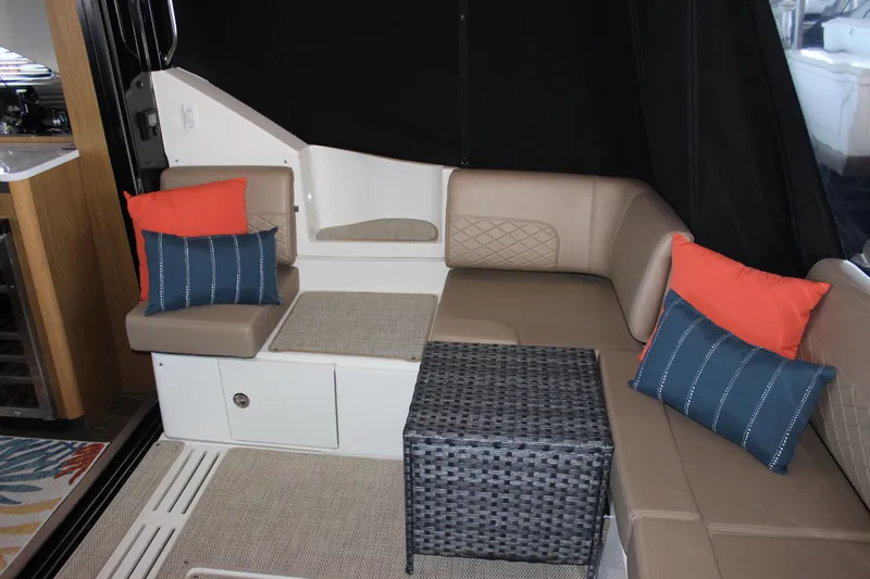  Yacht Photos Pics 2017 Sea Ray Fly 460 interior with beige seating, colorful cushions, and a wicker table.