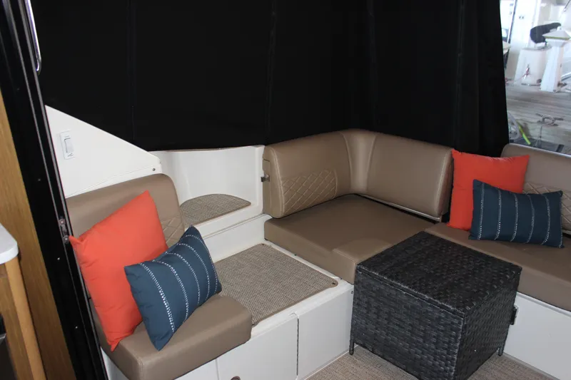  Yacht Photos Pics 2017 Sea Ray Fly 460 interior with beige seating, colorful cushions, and a wicker table.