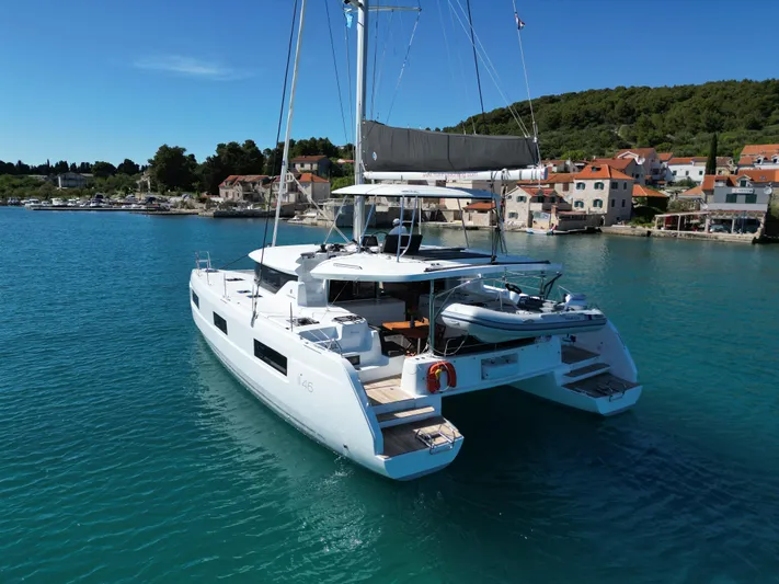 Mare Azul Yacht Photos Pics 2024 Lagoon 46 catamaran sailing in a serene coastal harbor.