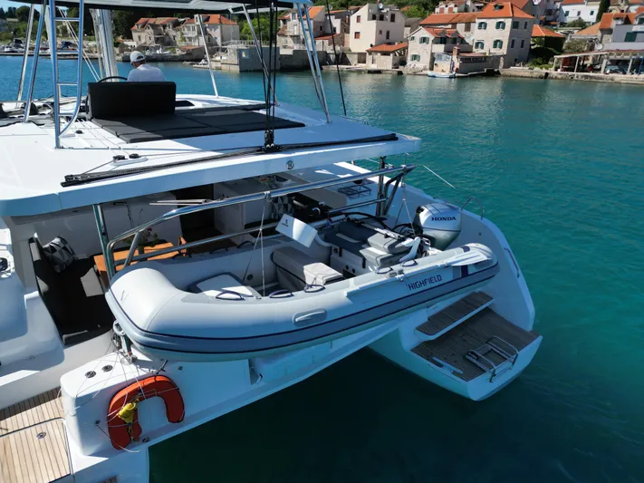 Mare Azul Yacht Photos Pics 2024 Lagoon 46 catamaran with dinghy, docked in a picturesque coastal village.