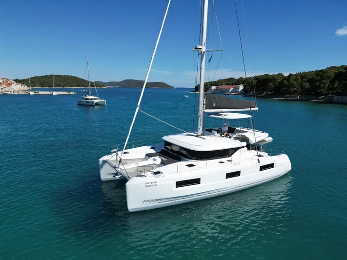 Mare Azul Yacht Photos Pics 2024 Lagoon 46 catamaran sailing in clear blue waters under a sunny sky.