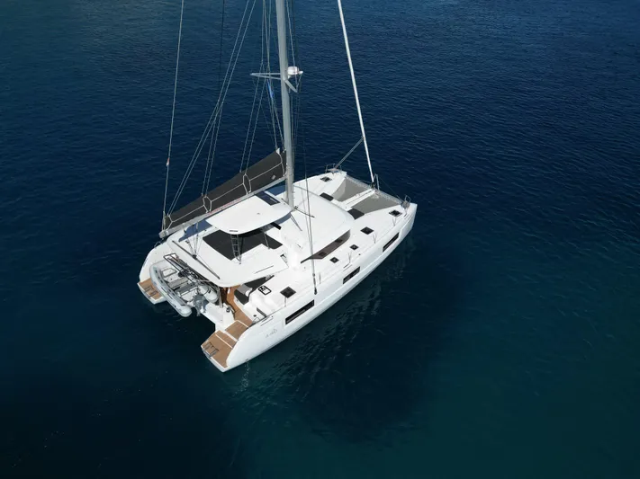 Mare Azul Yacht Photos Pics 2024 Lagoon 46 catamaran sailing on calm blue waters, aerial view.