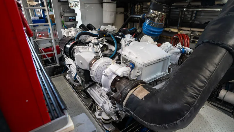  Yacht Photos Pics Engine room of a 1999 Burger 85 Deck House yacht, showcasing machinery and components.