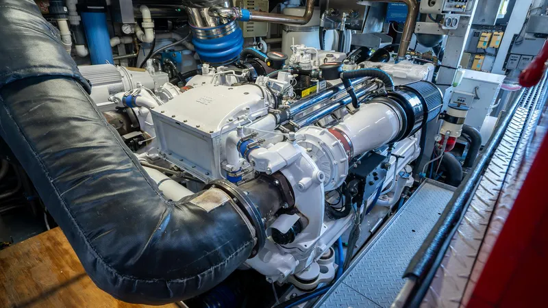  Yacht Photos Pics Engine room of 1999 Burger 85 Deck House yacht, showcasing complex machinery and components.