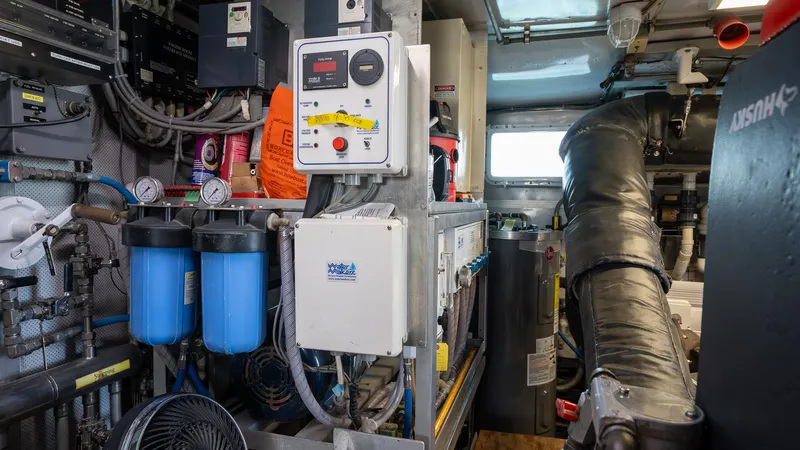  Yacht Photos Pics Engine room of a 1999 Burger 85 Deck house yacht, featuring filtration systems and control panels.