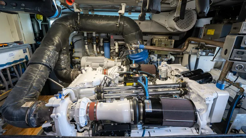  Yacht Photos Pics Engine room of 1999 Burger 85 Deck house yacht, showcasing complex machinery and components.