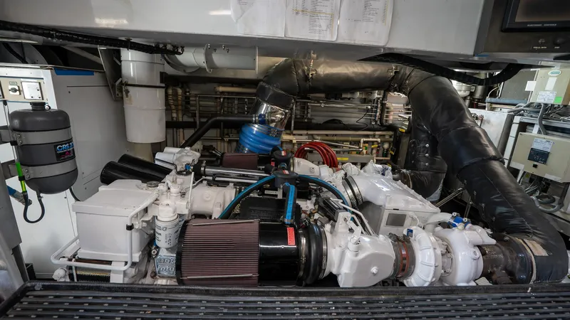  Yacht Photos Pics Engine room of a 1999 Burger 85 Deck House yacht, showcasing complex machinery and components.