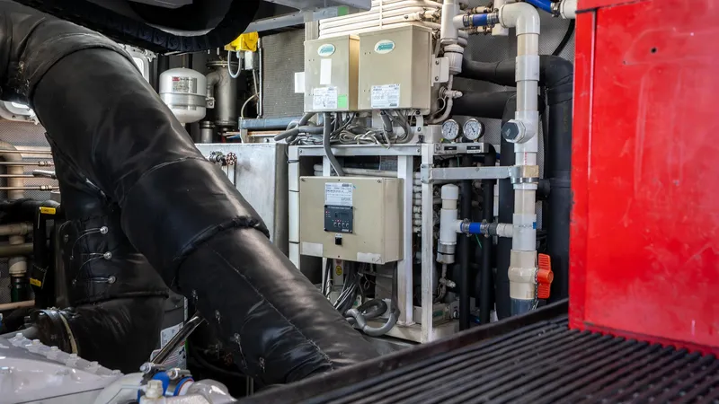  Yacht Photos Pics Engine room of a 1999 Burger 85 Deck house yacht, featuring complex machinery and piping.