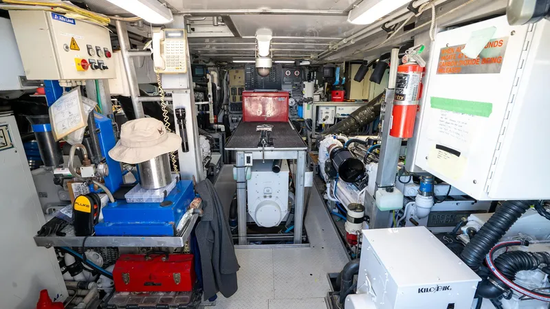  Yacht Photos Pics Engine room of a 1999 Burger 85 Deck House yacht, featuring various equipment and machinery.
