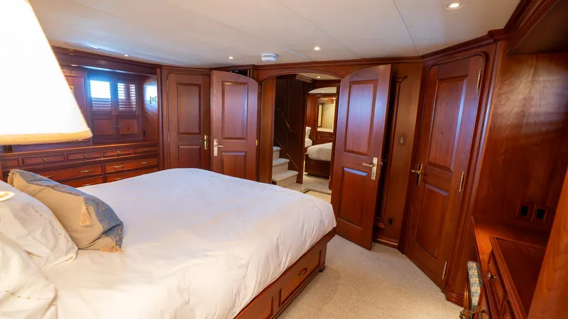  Yacht Photos Pics Luxurious bedroom interior on 1999 Burger 85 Deck house yacht, featuring elegant wood paneling.
