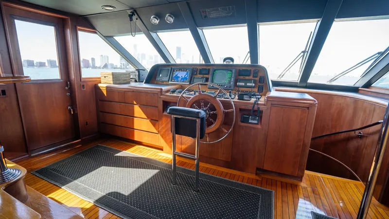  Yacht Photos Pics Luxurious 1999 Burger 85 Deck House yacht interior with wooden helm and navigation equipment.