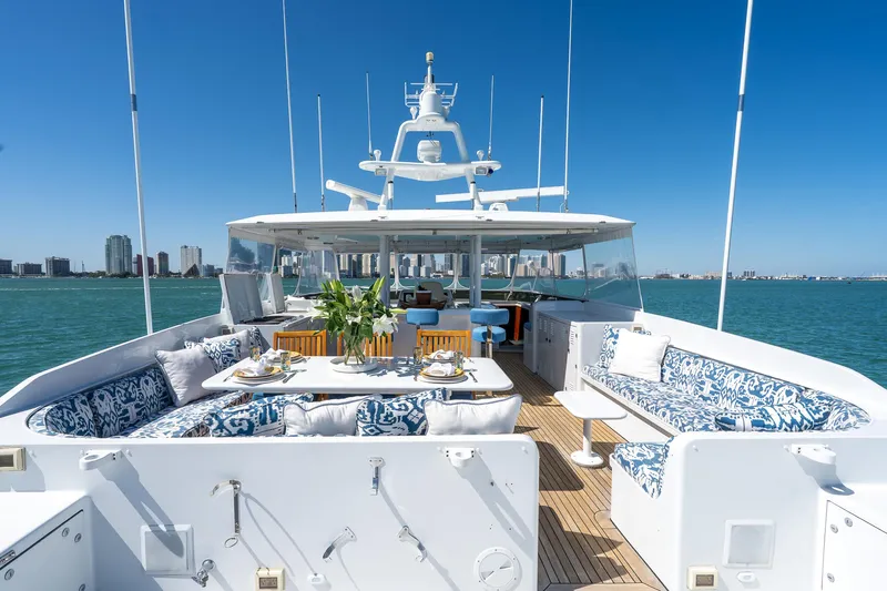  Yacht Photos Pics Luxurious 1999 Burger 85 Deck House yacht with elegant outdoor seating and ocean view.