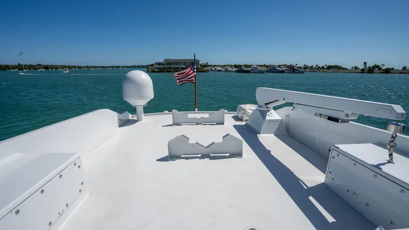  Yacht Photos Pics Deck view of 1999 Burger 85 Deck House yacht with American flag on calm waters.