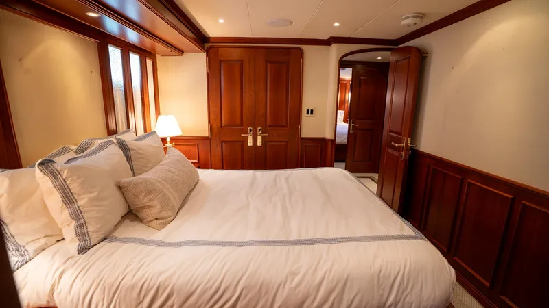  Yacht Photos Pics Luxurious bedroom in 1999 Burger 85 Deck house yacht with elegant wood paneling.