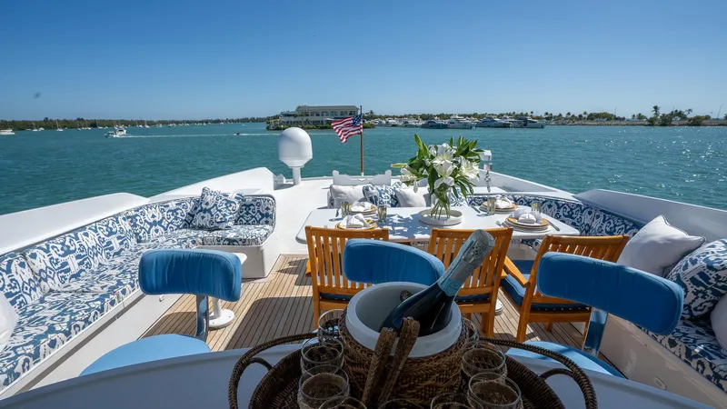  Yacht Photos Pics Luxurious 1999 Burger 85 Deck House yacht with elegant outdoor dining setup on serene waters.