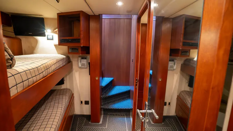  Yacht Photos Pics Interior of 1999 Burger 85 Deck House yacht with wooden bunk beds and stairs.