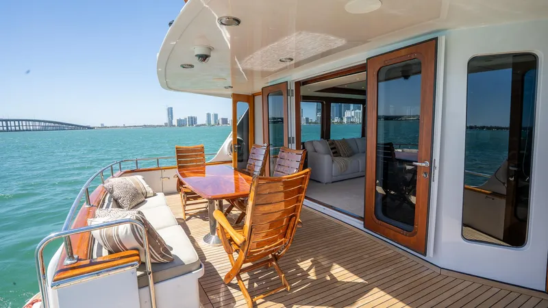  Yacht Photos Pics Luxurious 1999 Burger 85 Deck House yacht with elegant outdoor seating and ocean view.