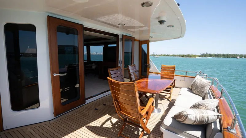  Yacht Photos Pics Luxurious 1999 Burger 85 Deck House yacht with elegant outdoor seating and ocean view.