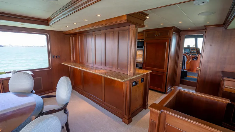  Yacht Photos Pics Luxurious interior of 1999 Burger 85 Deck house yacht with wooden paneling and elegant furnishings.