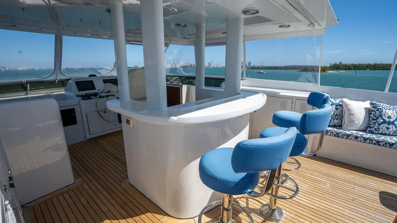  Yacht Photos Pics Luxurious 1999 Burger 85 Deck House yacht interior with bar and blue stools.